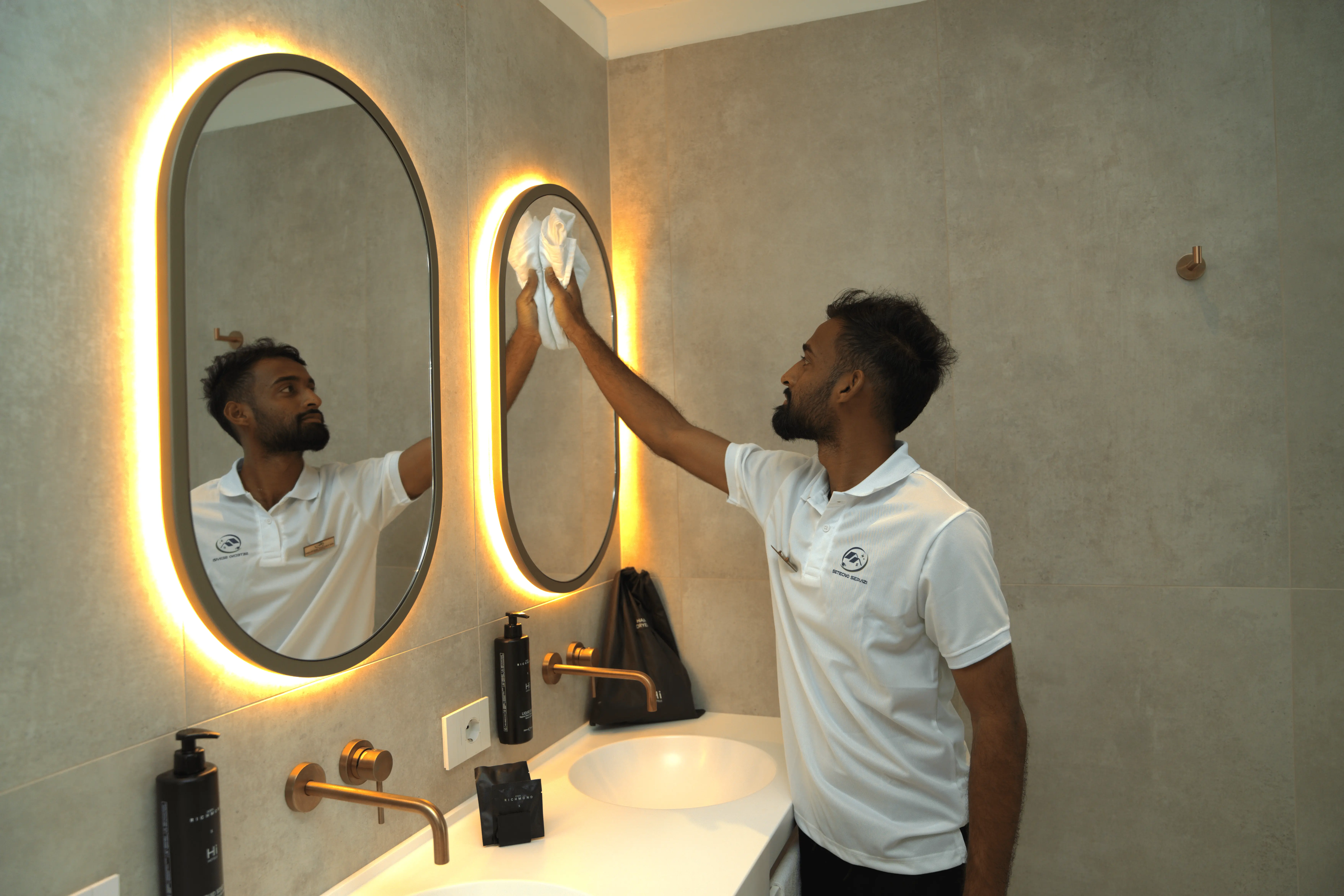 SETECNO SERVIZI SRLS professional polishing an illuminated bathroom mirror